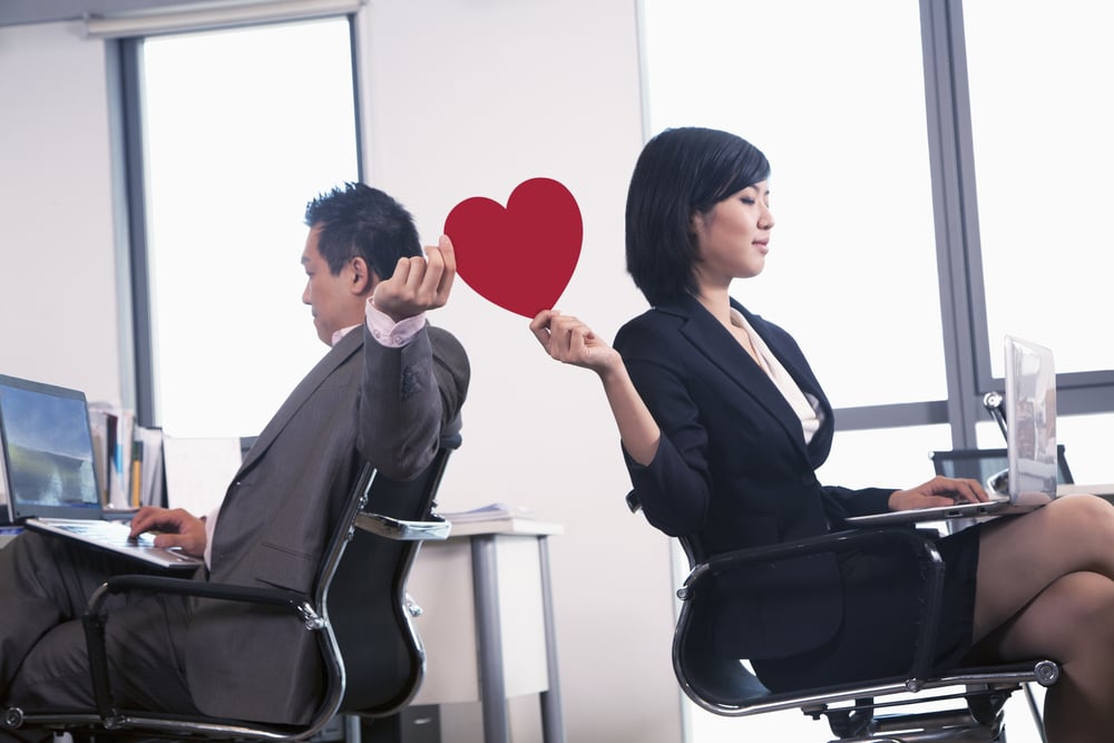 twee collega's geven een hart aan elkaar